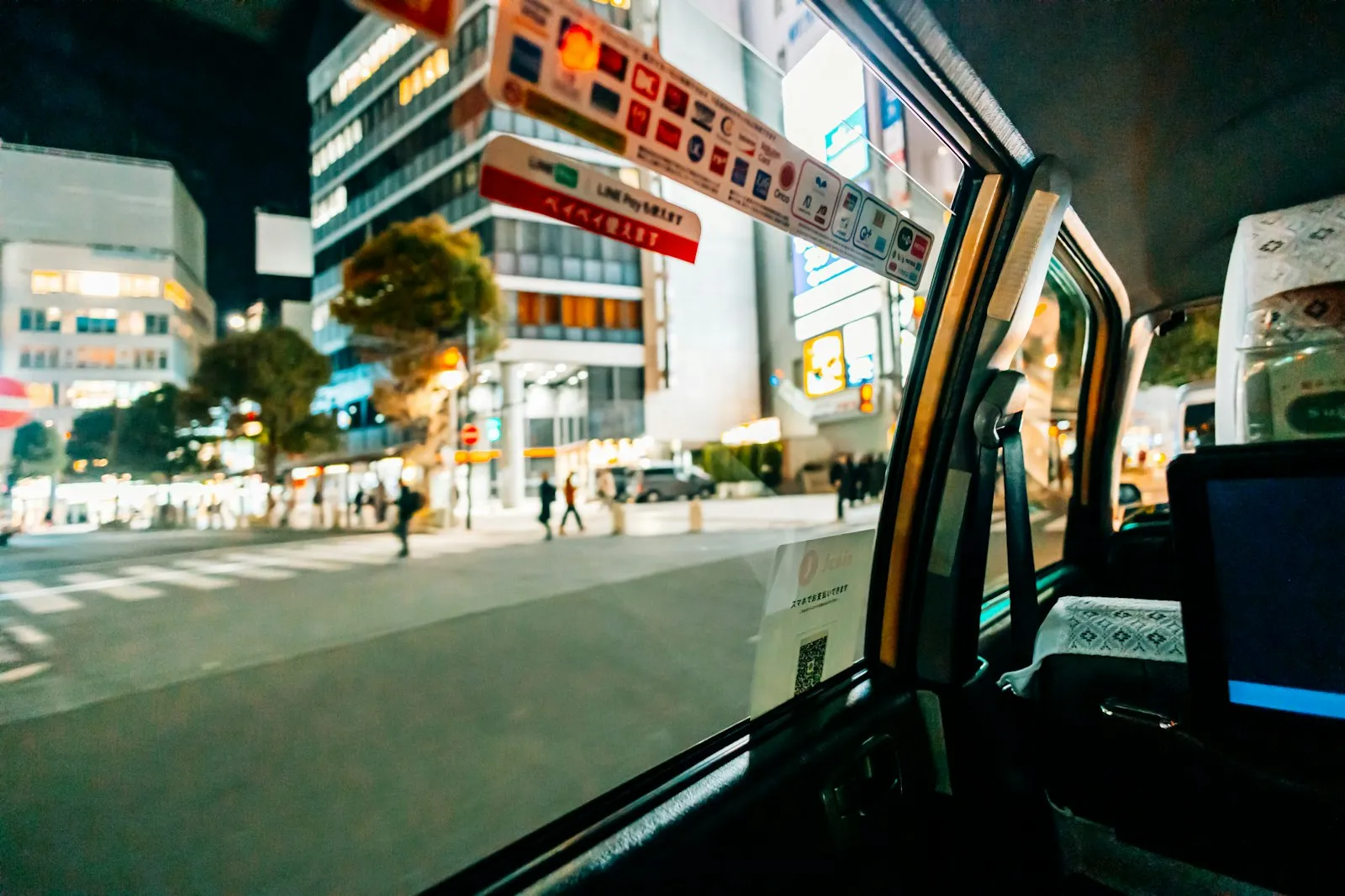 Taxichauffeur achter het stuur met smartphone